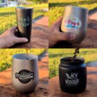 A collage of four images shows hands holding various metallic cups. Each cup features diverse coffee-themed designs and labels with vibrant colors, set against a grassy background. Coffee beans are seen being poured in one cup, and coffee is being poured into another, conveying a theme of enjoyment and relaxation.